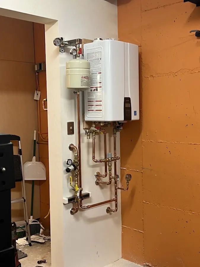 Plumbing technician inspecting water heater connections in Cedar Hills